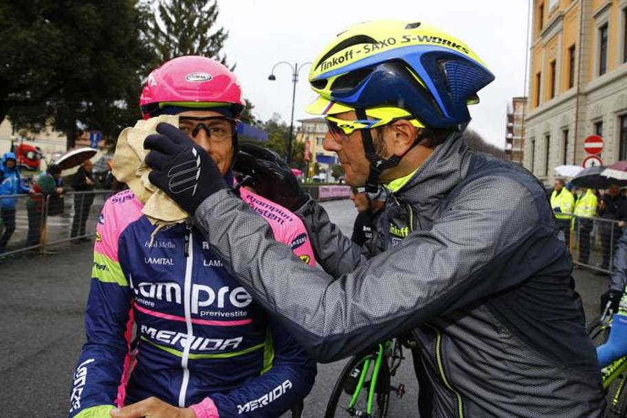 Ivan Basso pulisce preventivamente gli occhiali di Pozzato. Bettini